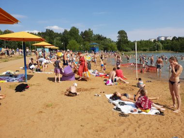 Moskova, Rusya - 23 Haziran 2019. İnsanlar Zelenograd 'daki Okul Gölü yakınlarındaki bir plajda dinleniyorlar.
