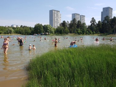 Moskova, Rusya - 23 Haziran 2019. İnsanlar Zelenograd 'daki Okul Gölü yakınlarındaki bir plajda dinleniyorlar.