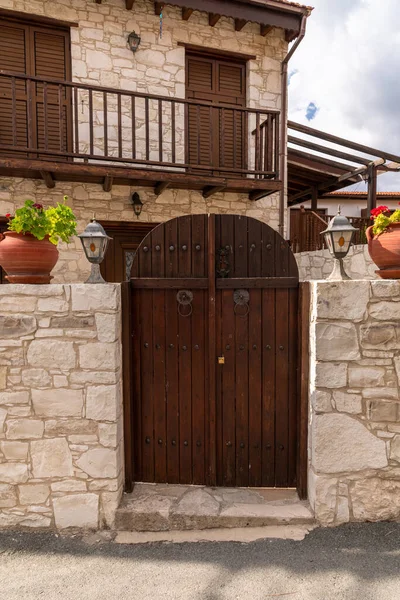 Wooden gate and stone fence in front of the house in Cyprus