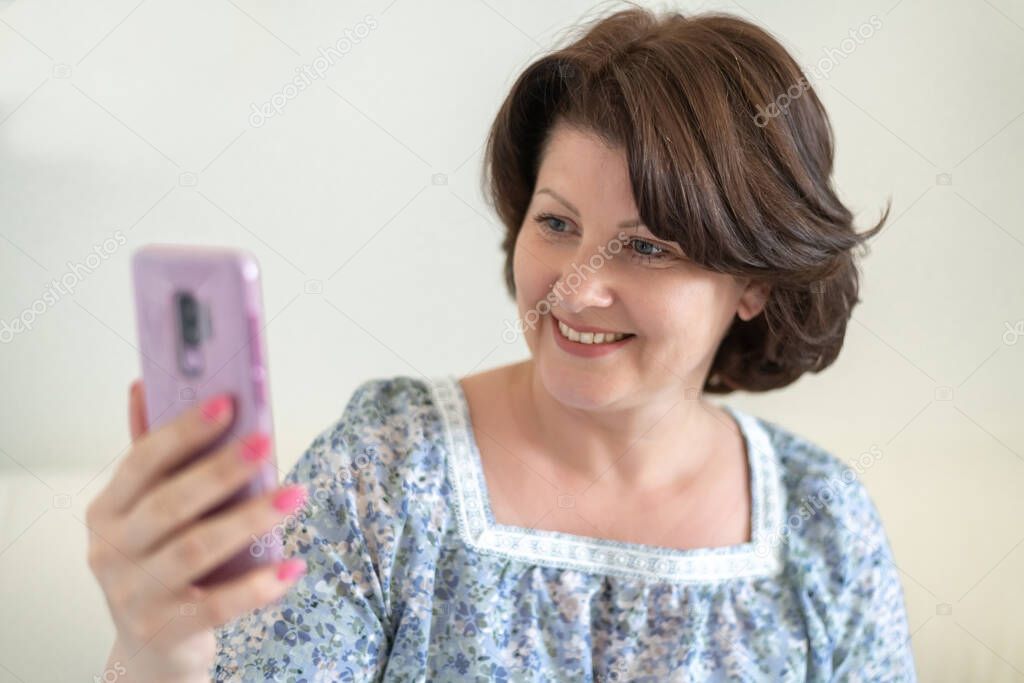 Portrait of a woman with asmile looking at a cellphone