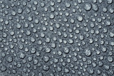 Üzerinde mavi bir arka plan şeffaf saf su damlacıkları. Damla su yakın çekim.