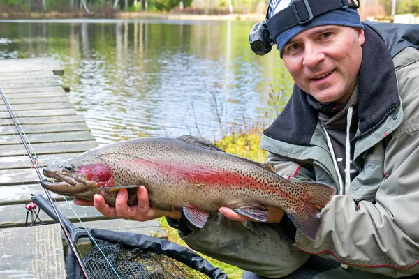 Pescador con trucha arco iris — Foto de Stock