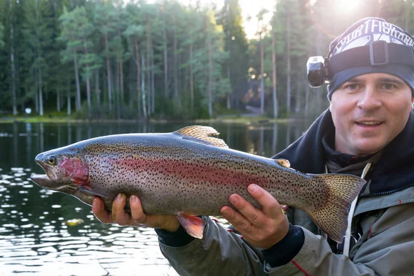 Pescador con trucha arco iris — Foto de Stock