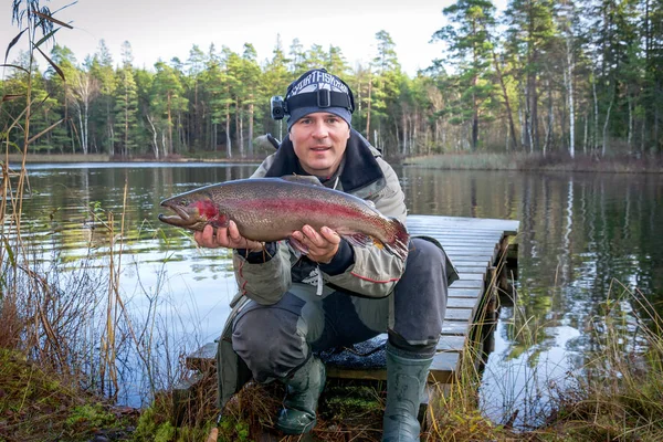 Pescador com truta arco-íris — Fotografia de Stock