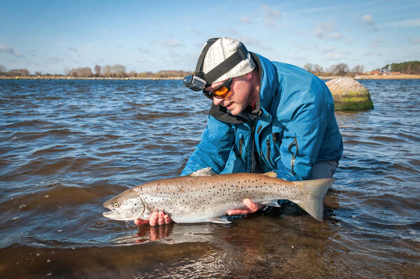 Angler releasing the sea trout fish