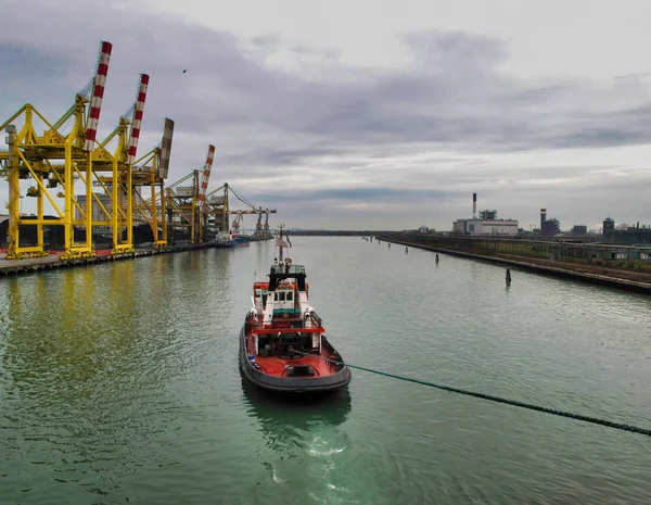 Tug boat mooving a big ship inside marghera harbour — Stock Photo, Image