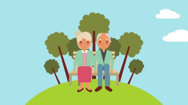 Bejaarde echtpaar zittend op een bankje in het park — Stockvideo