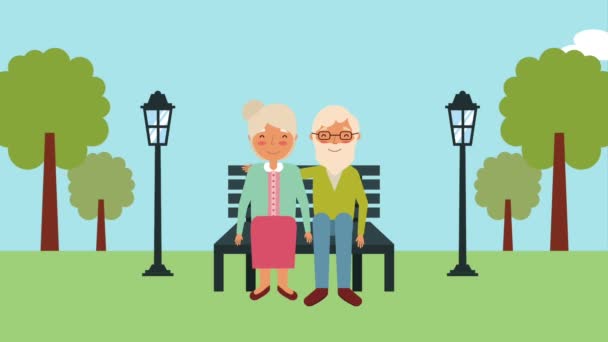 Elderly couple sitting on bench in the park — Stock Video