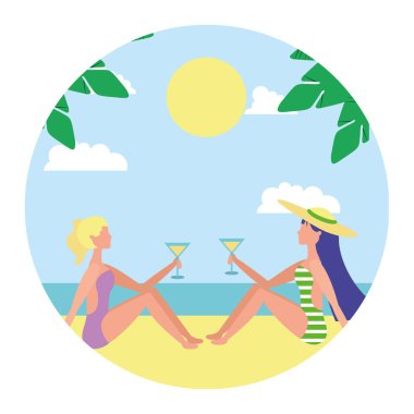 elinde kokteyller ile sahilde oturan iki kadın