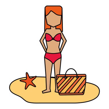 Kumsalda çantası olan bikinili bir kadın.