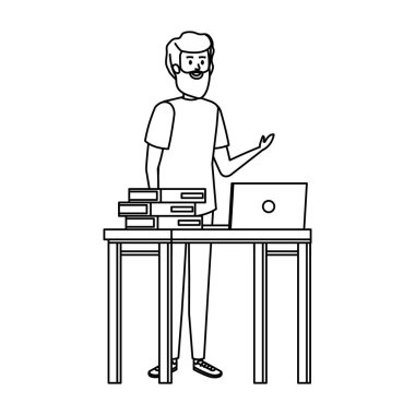 Genç öğretmen dizüstü bilgisayar ve kitaplarla masada.