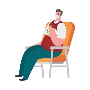Korumacı tıbbi maske takan bir adam. 19 yaşında, sandalyeye oturmuş, ev konseptinde oturuyor.