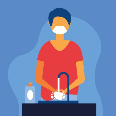 Maskeli bir adam ellerini yıkıyor.