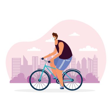 Sağlık maskesi takmış bisiklet sporu yapan genç bir adam.