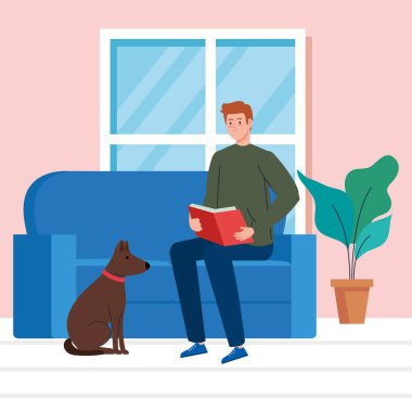 Adam evde kitap okuyor, köpek maskotuyla kanepede oturuyor.