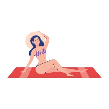 Mayosu olan bir kadın yaz şapkasını havluda otururken kullanıyor. Tatil sezonu.