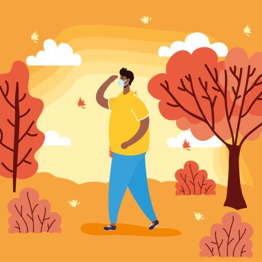 Sonbahar sezonunda tıbbi maske takan afro genç adam.