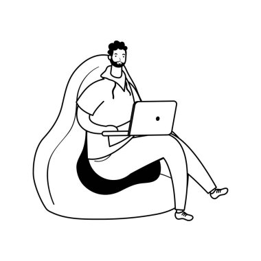 Dizüstü bilgisayarda çalışan genç adam kanepede oturuyor.