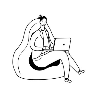 Dizüstü bilgisayarda çalışan genç adam kanepede oturuyor.