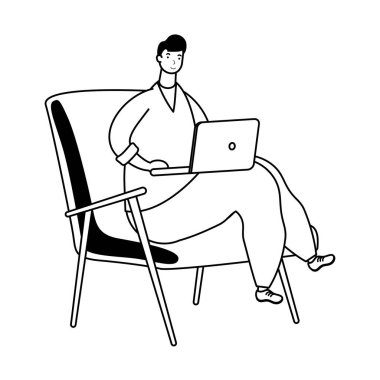 Dizüstü bilgisayarda çalışan genç adam kanepede oturuyor.