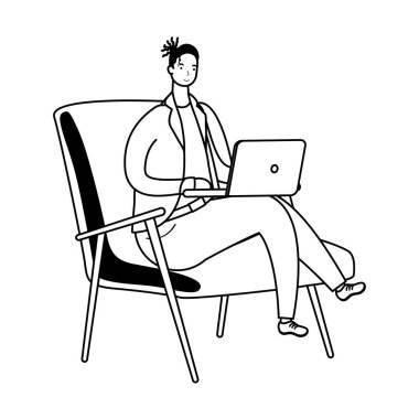 Dizüstü bilgisayarda çalışan genç adam kanepede oturuyor.