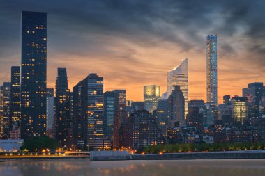 Günbatımında şehir gökdelenleri olan New York City silueti, ABD.