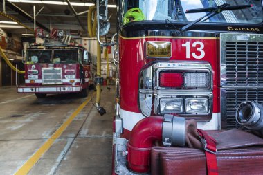 Chicago İtfaiye Departmanı 'nın 5. Şubesi' ndeki gerçek itfaiye aracının yanındaki itfaiyeci kıyafetleri. 10 Ekim 2018. Efsanevi Chicago Yangını haberi.