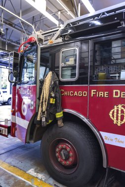 Chicago İtfaiye Departmanı 'nın 5. Şubesi' ndeki gerçek itfaiye aracının yanındaki itfaiyeci kıyafetleri. 10 Ekim 2018. Efsanevi Chicago Yangını haberi.