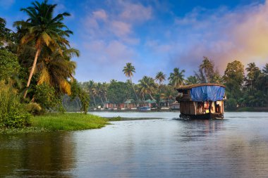 Geleneksel bir ev teknesi Kerala 'nın tatil köyü Kerala, Hindistan' da bir balıkçı gölünün kıyılarına demir atmıştır.