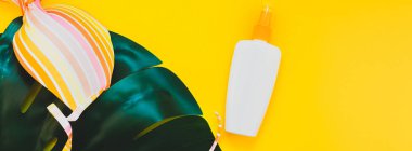 Tropikal orman palm monstera, güneş koruyucu boş şişe mockup ve kadının mayo parlak sarı Kağıt arka plan üzerinde bırakır. Yaz yaratıcı düz yatıyordu kavramı Şablon metnini tatiller. Uzun geniş afiş