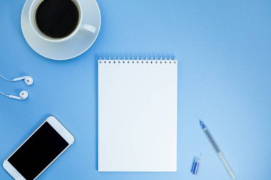 Yaratıcı düz kağıt defter, smartphone, earpieces, kalem ve kopya alan arka plan en az stili ile kahve ile fotoğraf çalışma masası göklere