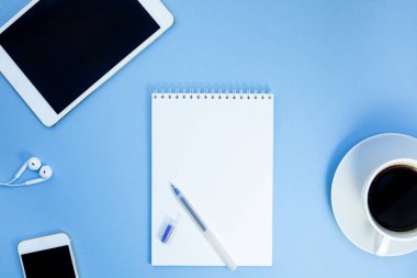 Yaratıcı düz kağıt defter, smartphone, earpieces, kalem ve kopya alan arka plan en az stili ile kahve ile fotoğraf çalışma masası göklere
