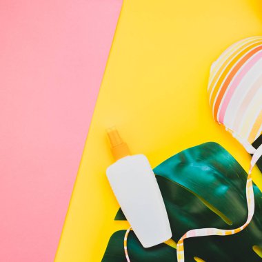 Tropikal orman palm monstera bırakır, güneş gözlüğü, Güneş kremi boş şişe mockup ve kadının mayo üst parlak kare renkli kağıt arka plan üzerinde. Yaz tatil yaratıcı düz yatıyordu kavramı şablonu