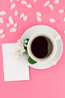 Yaratıcı düz kavramı üstten görünüm kahve Kupası yatıyordu ve beyaz elma ağacı yaprakları kartpostal sahte pastel pembe zemin üzerine kadar çiçekler ve alanı en az tarzı, metin için şablon kopyalama
