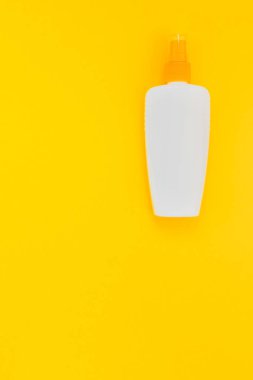 Güneş kremi boş şişe mockup parlak sarı Kağıt arka plan üzerinde. Metin için yaratıcı düz yatıyordu kavramı şablon yaz tatil