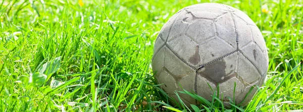 旧足球被遗忘在青草地里 足球的概念 长宽横幅 — 图库照片