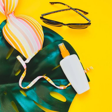 Tropikal orman palm monstera bırakır, güneş gözlüğü, Güneş kremi boş şişe mockup ve kadının mayo üstüne parlak kare Kağıt arka plan sarı. Yaz tatil yaratıcı düz yatıyordu kavramı şablonu