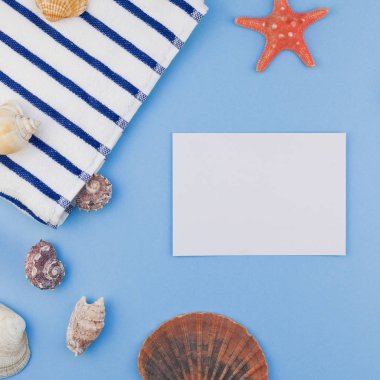 Yaratıcı kare düz yaz seyahat tatil kavramı yatıyordu. Kopya alanı en az tarzı, metin için şablon pastel mavi zemin üzerine plaj havlusu ve kabukları ve denizyıldızı Üstten Görünüm