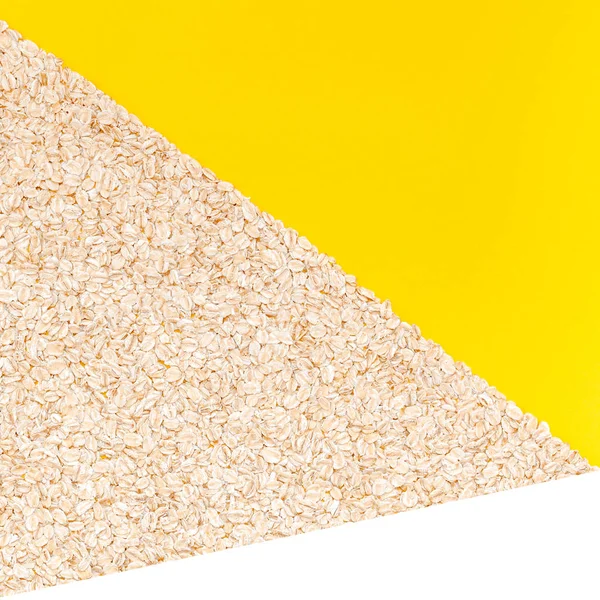 オートミールの創造的なフラット レイアウト コンセプト平面図はミニマル スタイル 正方形のテンプレート コピー スペースを持つ明るい黄色の色用紙の背景の朝食の健康とベジタリアンの有機食品のフレークします — ストック写真