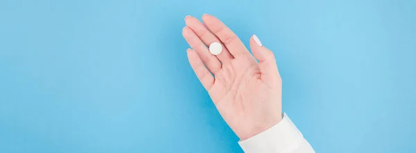 Mano Mujer Sosteniendo Una Píldora Blanca Sobre Fondo Papel Azul —  Fotos de Stock