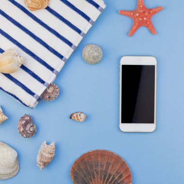 Yaratıcı kare düz yaz seyahat tatil kavramı yatıyordu. Plaj havlusu, deniz kabuklarını, deniz yıldızı ve pastel mavi arka plan kopya alanı en az tarzı, metin için şablon ile smartphone Üstten Görünüm