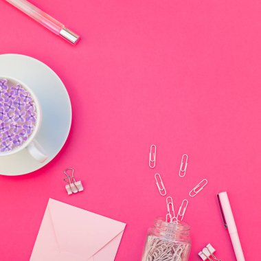 Üstten görünüm düz parlak pembe renk Kağıt arka plan en az stili üzerinde kopya alanı tasarım ofis malzemeleri tarz çalışma masası ve çay yatırın. Kadınsı blog sosyal medya için kare şablon