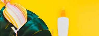 Tropikal orman palm monstera, güneş koruyucu boş şişe mockup ve kadının mayo parlak sarı Kağıt arka plan üzerinde bırakır. Yaz yaratıcı düz yatıyordu kavramı Şablon metnini tatiller. Uzun geniş afiş