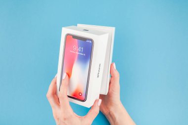 Berlin, Almanya - 24 Mayıs 2018: parlak mavi arka planı renkli kutuyu son Apple iphone X 10 akıllı telefon holding kadın eller. Unboxing kavramı kopya alanı ile