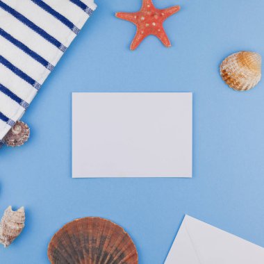 Yaratıcı kare düz yaz seyahat tatil kavramı yatıyordu. Kopya alanı en az tarzı, metin için şablon pastel mavi zemin üzerine plaj havlusu ve kabukları ve denizyıldızı Üstten Görünüm