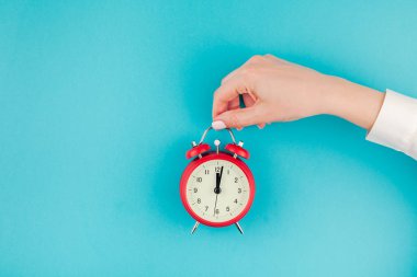 Yaratıcı düz yatıyordu kavramı üstten görünüm kadının el Beyaz gömlek kırmızı vintage çalar saat parlak mavi turkuaz renkli kağıt arka plan kopya alanı ile üzerinde en az stil, şablon metin için holding