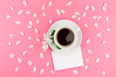 Yaratıcı düz kavramı üstten görünüm kahve Kupası yatıyordu ve beyaz elma ağacı yaprakları kartpostal sahte pastel pembe zemin üzerine kadar çiçekler ve alanı en az tarzı, metin için şablon kopyalama