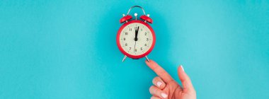 Yaratıcı düz yatıyordu kavramı kırmızı vintage çalar saat parlak mavi turkuaz üzerinde tutan kadın el üst görünümünü renk Kağıt arka plan kopya alanı ile minimal tarzda uzun geniş afiş