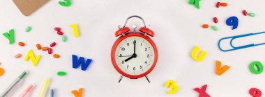 Beyaz masa arka plan kopya alanı, çerçeve, metin veya tasarım şablonu ile üzerinde uzun geniş afiş geri okul kavramı çalar saat, renk okul ve ofis malzemeleri
