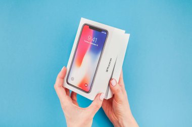 Berlin, Almanya - 24 Mayıs 2018: parlak mavi arka planı renkli kutuyu son Apple iphone X 10 akıllı telefon holding kadın eller. Unboxing kavramı kopya alanı ile